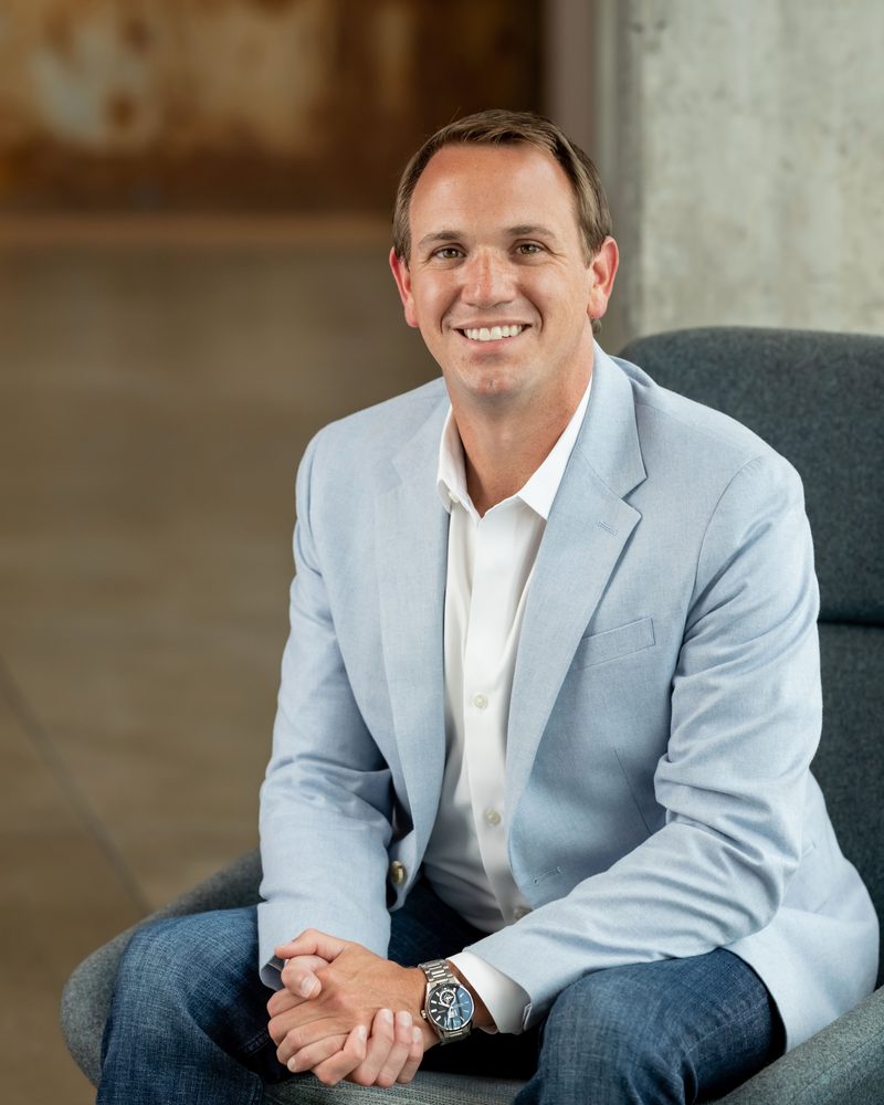 Brian Onorio seated in a light blue blazer, smiling